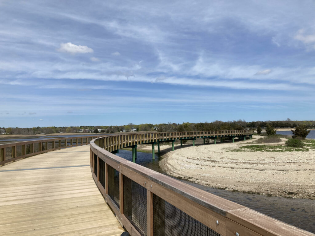 Elevated bicycle path over beach and river.