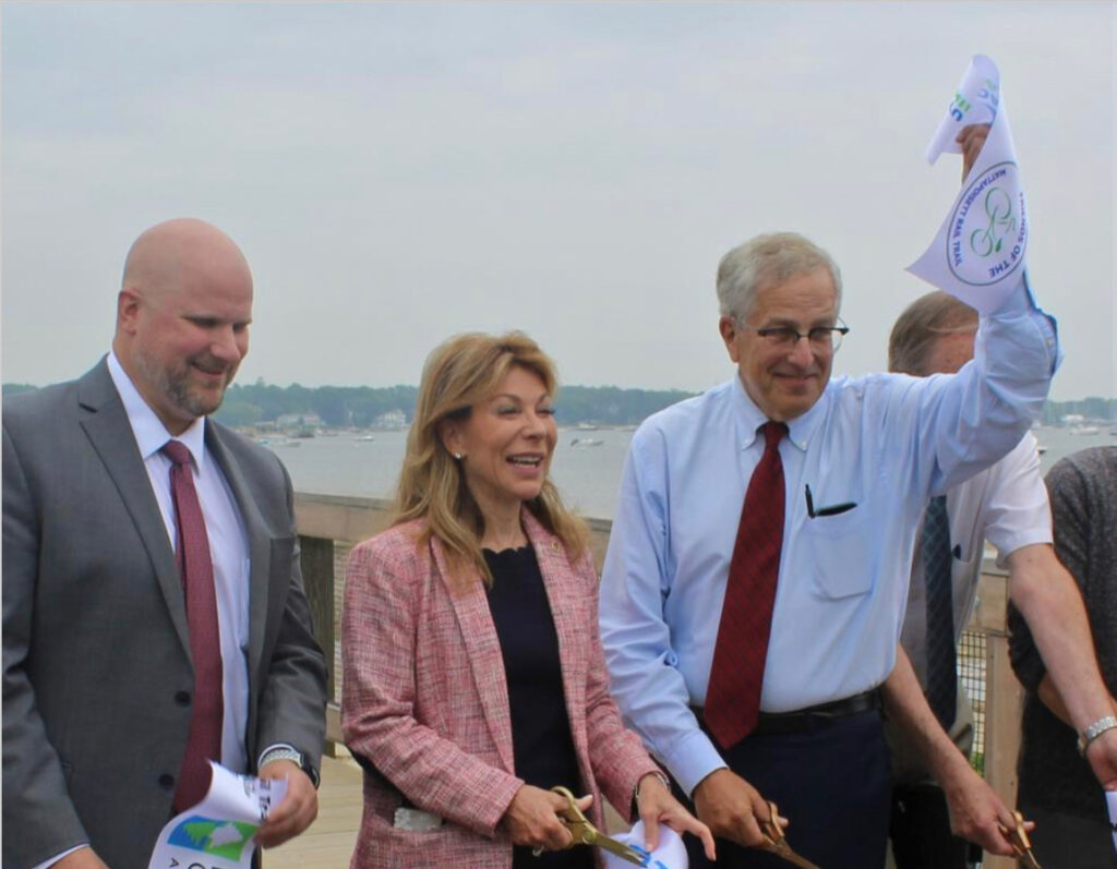 10th Bristol Representative William Straus (D- Mattapoisett) holds up the freshly cut ribbon, Massachusetts Department of Transportation Secretary and CEO Gina Fiandaca and State Highway Administrator Jonathan Gulliver stand left